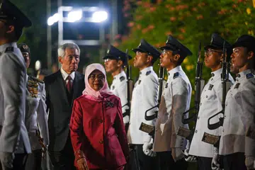 PEMERIKSAAN TERAKHIR: Pemeriksaan pengawal terakhir Mantan Presiden Halimah Yacob. Perdana Menteri Encik Lee Hsien Loong mengiringi Puan Halimah.