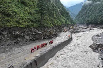 Anggota bomba dan penyelamat menjalankan operasi mencari dan menyelamat di laluan jalan yang menuju ke Pelabuhan Gyirong, di Daerah Gyirong, di wilayah Tibet di barat China pada 28 Ogos.