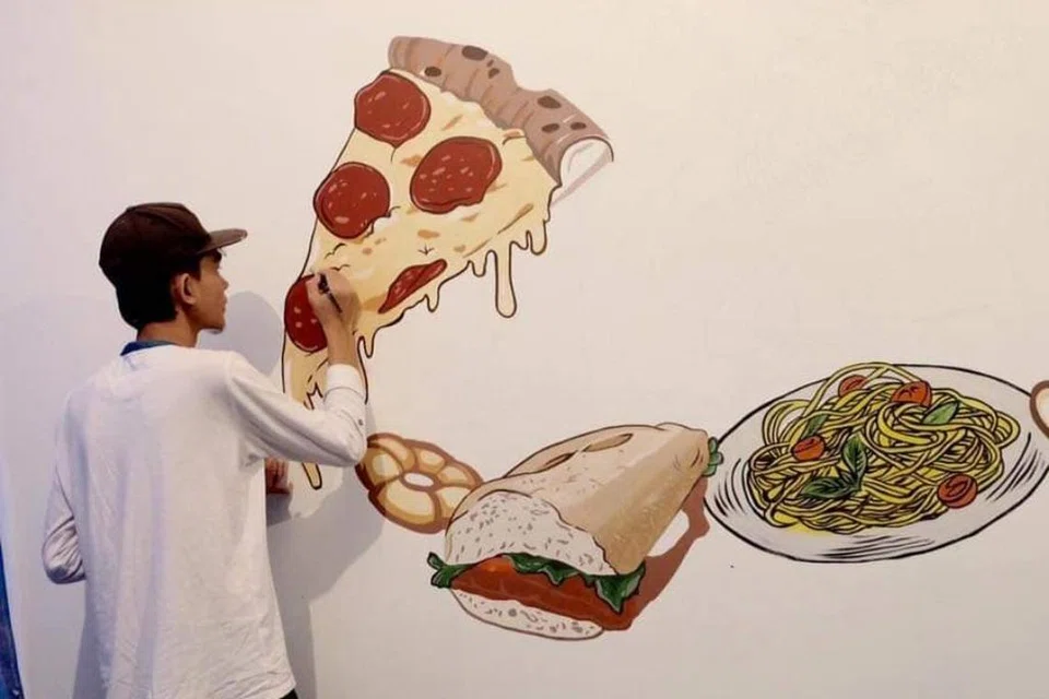 LUKIS DI SINGAPURA: Muhammad Nabil kelihatan melukis bentuk pizza bagi restoran Al-Azhar di Bukit Timah pada 2016.