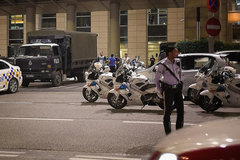 KEHADIRAN POLIS: Anggota polis mengawal di sekitar kondominium di Kuala Lumpur.