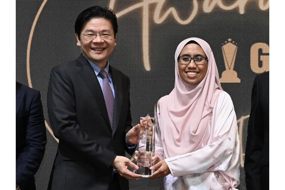 PEMENANG USAHAWAN WANITA TERBAIK: Pemilik Kowabunga! Global, Cik Nur Suliani Md Noor, menerima anugerahnya dari Encik Wong. - Foto BH oleh KHALID BABA 