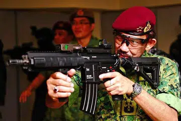 MENEMBAK: Sultan Hassanal Bolkiah berpeluang menembak beberapa peluru latihan semasa melawat Kem Pasir Ris semalam. - Foto MINDEF