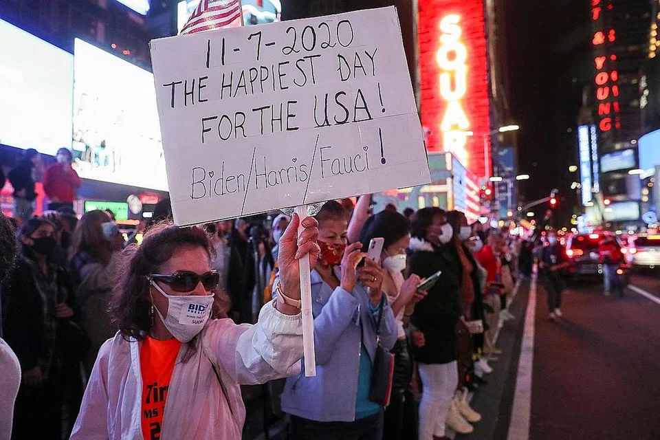 MENJULANG IMPIAN: Rakyat Amerika meraikan kemenangan Encik Biden dan Cik Kamala Harris di Times Square, New York City - Foto REUTER