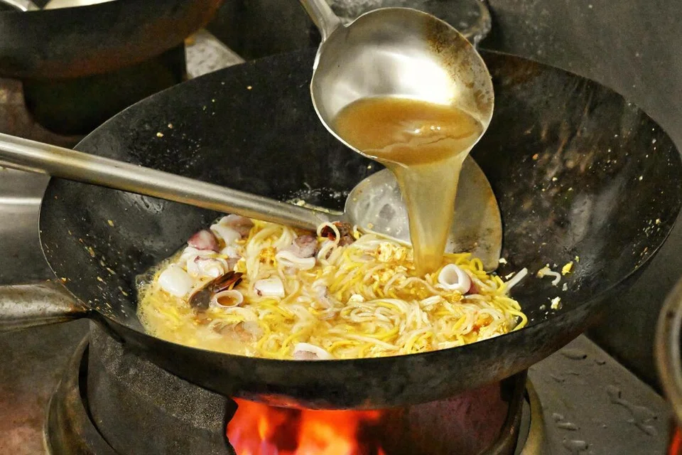 Stok udang dituang ke atas mi untuk membolehkan semua bahan menyerap sepenuhnya sebelum udang dimasukkan.