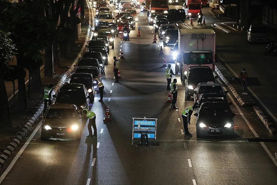 DI KUALA LUMPUR - BANDAR JADI SEPI: Jalan raya yang biasanya sibuk di kawasan dekat KLCC ini berubah menjadi sunyi sejak Perintah Kawalan Pergerakan berkuat kuasa di Malaysia pada 18 Mac 2020. Sementara itu, pegawai polis dikerah memeriksa kenderaan semasa menjalankan operasi sekatan jalan raya di Kuala Lumpur bagi memastikan orang ramai mematuhi peraturan itu (gambar atas). - Foto-foto REUTERS