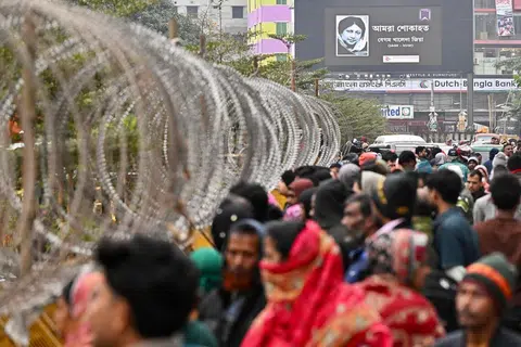 Sebuah papan iklan yang memaparkan gambar mendiang bekas perdana menteri Bangladesh, Khaleda Zia, dipasang di luar Hospital Evercare yang dikawal ketat di Dhaka pada 30 Disember 2025. Khaleda Zia, yang diyakini ramai bakal mencatat kemenangan besar dalam pilihan raya tahun hadapan untuk kembali menerajui negara itu, meninggal dunia pada 30 Disember pada usia 80 tahun, menurut kenyataan Parti Kebangsaan Bangladesh.