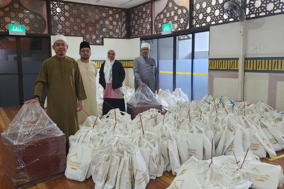BERSATU HATI: Ustaz Badrussalam Dja’far (paling kanan) dan Cik Faridah Markalee (berjaket hitam) bersama dua lagi, sama-sama menyumbang khidmat untuk Masjid Hasanah di pameran Singapore Expo.