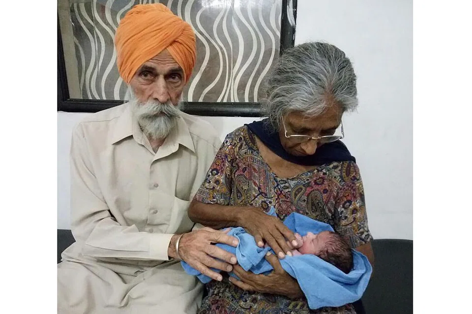 ANAK SENDIRI: Cik Daljinder Kaur mendukung anak lelaki yang dilahirkannya bulan lalu. Bersama beliau ialah suaminya, Encik Mohinder Singh Gill, 79 tahun. - Foto AFP