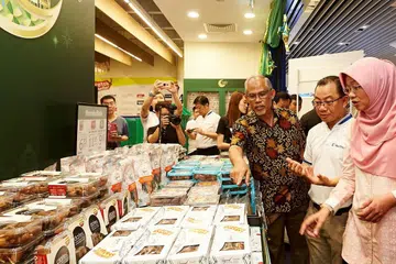HARGAI SUMBANGAN: Encik Masagos (tiga dari kanan) berasa kagum dengan pelbagai jenis kurma yang kini dijual di NTUC FairPrice sambil disaksikan Encik Seah (dua dari kanan) dan Cik Rahayu (kanan). - Foto BH oleh ROSLEE ABDUL RAZAK