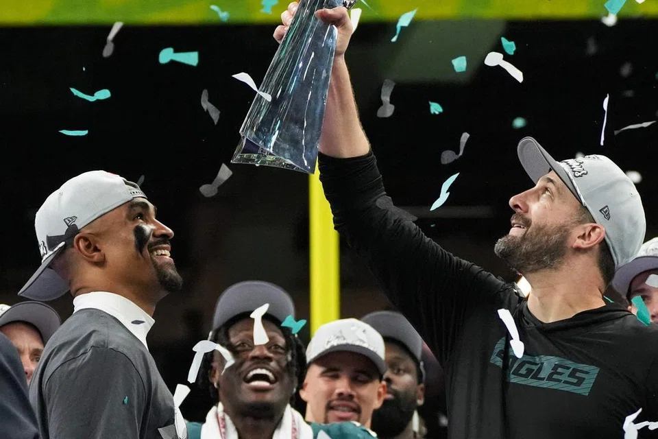 Ketua jurulatih Philadelphia Eagles, Nick Sirianni (kanan), menjulang trofi kejuaraan ‘Super Bowl’ dengan diperhatikan kapten pasukan, Jalen Hurts (kiri), serta rakan-rakan lain dalam pasukan. Pasukan itu menewaskan  Kansas City Chiefs 40-22 dalam pertarungan akhir di Caesars Superdome, New Orleans, Louisiana, pada 9 Februari.