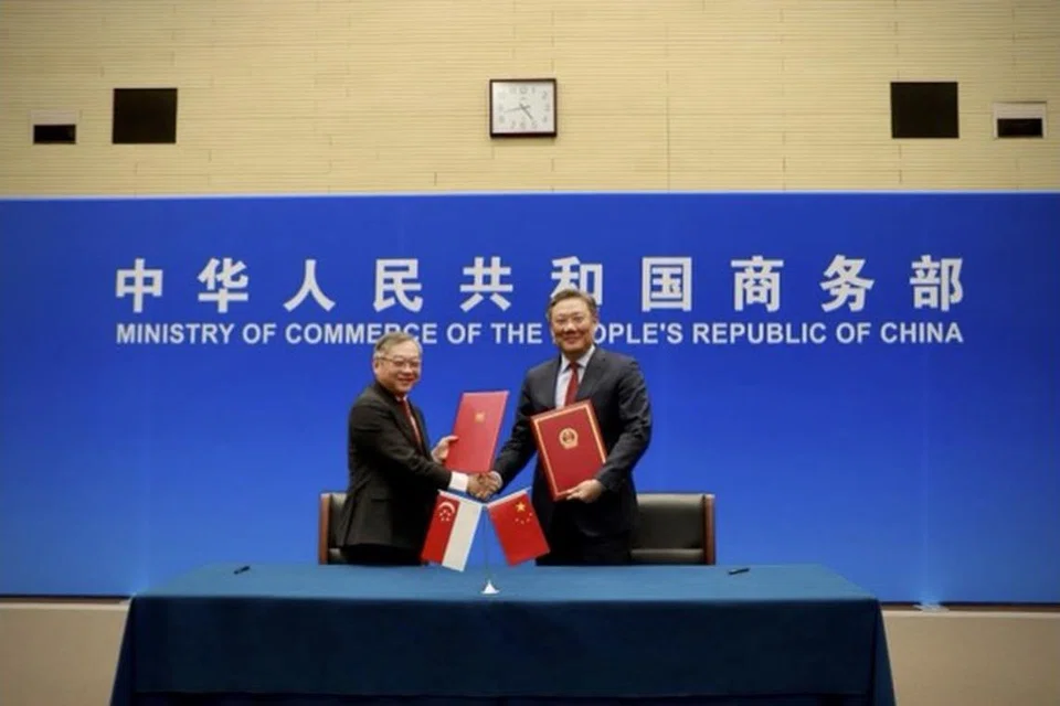 KERJASAMA DUA HALA: Menteri Perdagangan dan Perusahaan, Encik Gan Kim Yong (kiri), dan Menteri Perniagaan China, Encik Wang Wentao (kanan), menandatangani Protokol Peningkatan Lanjut Perjanjian Dagangan Bebas China-Singapura (CSFTA) di mesyuarat Majlis Bersama bagi Kerjasama Dua Hala (JCBC) ke-19 pada 7 Disember di Tianjin, China.