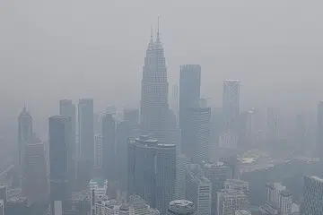 KEADAAN BERJEREBU: Beberapa mercu tanda di Malaysia, termasuk Menara Berkembar Petronas 'ditelan' jerebu pada tengah hari semalam ekoran kualiti udara rendah akibat fenomena jerebu. - Foto AFP