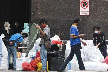 PAKAI PELITUP: Penduduk di Jakarta dilihat memakai pelitup semasa berada di luar sebuah pasar di ibu kota Indonesia itu. - AFP