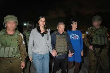 PERTAMA DIBEBASKAN: Warga Amerika, (dua dari kanan) Cik Judith Tai Raanan dan anaknya, (dua dari kiri), Natalie Shoshana Raanan, berjalan sambil dipimpin oleh Brigadier Jeneral Israel, Gal Hirsch, ketua perunding tebusan IDF, selepas dibebaskan oleh kumpulan Hamas hasil usaha pengantaraan pihak Qatar.