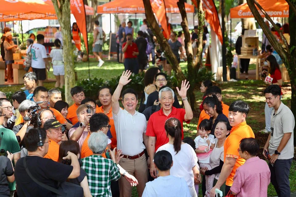 Menteri Kanan, Encik Lee Hsien Loong (tengah, berbaju merah), ditemani Anggota Parlimen (AP) Kebun Baru, Encik Henry Kwek (berbaju putih) di Karnival Ahad Kebun Baru, pada 6 April.