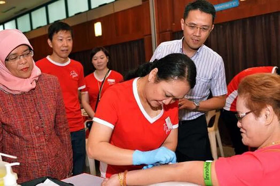 PRIHATIN PADA KESIHATAN: Speaker Parlimen, Cik Halimah Yacob menggalakkan penduduk Bukit Batok East menjalani pemeriksaan kesihatan dalam satu Karnival Mega Kesihatan Masyarakat Bukit Batok East semalam. Turut bersama ialah Pengerusi jawatankuasa penganjur, Encik Ng Kian Swan (dua dari kiri) dan Ketua Pegawai Eksekutif Jurong Health, Encik Foo Hee Jug (kanan) - Foto KHALID BABA 