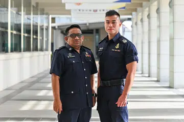 Penolong Superintenden Polis (ASP) Abdul Rahman Mohamad Karim (kiri) dan Staf Sarjan Kanan (SSS) Woon Guo Jin, segera bertindak semasa insiden kebakaran di ladang ternakan ikan di luar Pulau Tekong pada  21 Januari 2024. 
