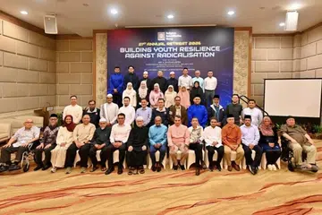 Menteri Penyelaras bagi Keselamatan Negara merangkap Menteri Ehwal Dalam Negeri, Encik K. Shanmugam (barisan depan, tengah), diapit Pengerusi Bersama Kumpulan Pemulihan Keagamaan (RRG), Ustaz Dr Mohamed Ali (kanan) dan Ustaz Dr Mohamad Hasbi Hassan, ketika bergambar dengan peserta Rahat Tahunan RRG ke-21 pada 2 Jun.