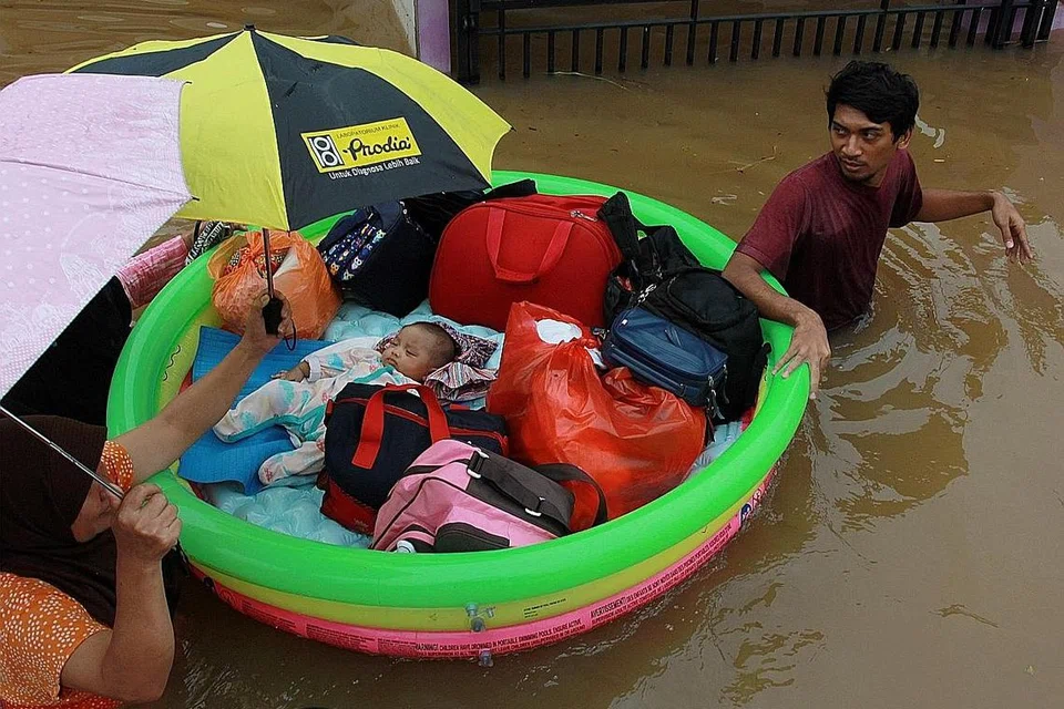 KESAN BANJIR...: DIPINDAHKAN: Seorang bayi dipindahkan pasukan penyelamat selepas banjir kilat melanda kawasan perumahan di Tangerang dekat Jakarta, Indonesia pada 1 Januari 2020. - Foto REUTERS