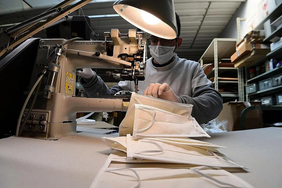 TERDESAK TAMBAH PENGELUARAN PELITUP: Pekerja ini - di sebuah kilang do Lombardy, Italy, yang sebelum ini menghasilkan barangan kulit tetapi mengalihkan tumpuan bagi menghasilkan pelitup - giat menjahit pelitup-pelitup yang permintaannya semakin meningkat. Italy antara negara Eropah yang paling teruk terjejas wabak koronavirus. - Foto AFP