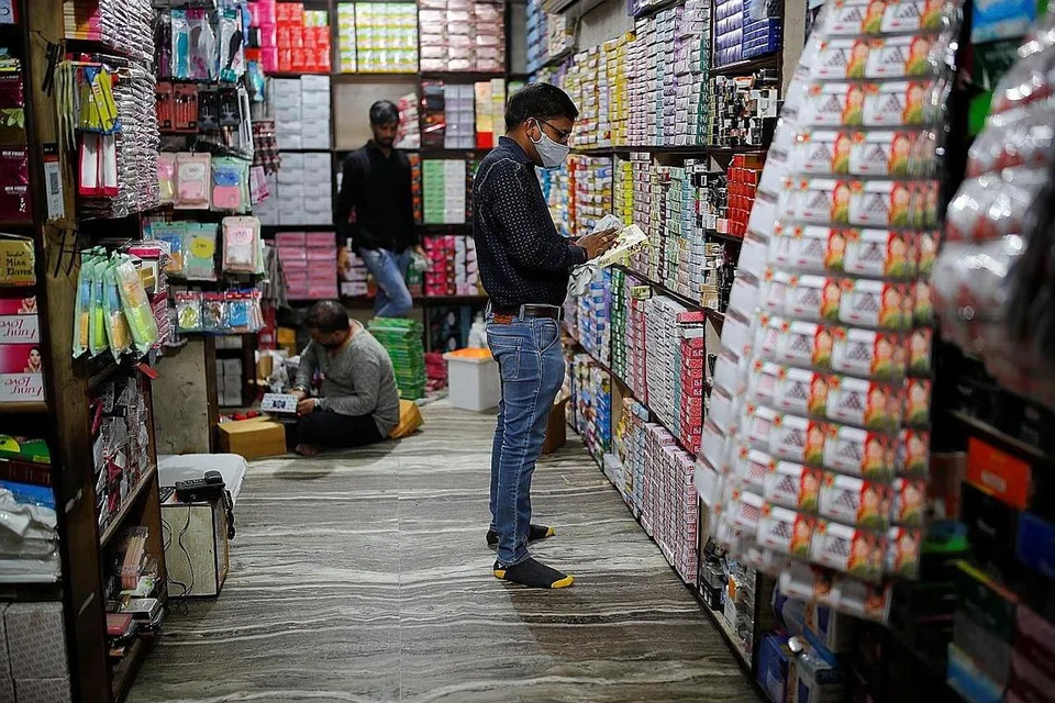 BERSIAP SAMBUNG OPERASI: Seorang pekerja membersihkan barangan di sebuah kedai di sebuah pasar di New Delhi, selepas pihak berkuasa India melonggarkan sekatan keluar masuk (lockdown) yang dilaksana sejak April. - Foto REUTERS