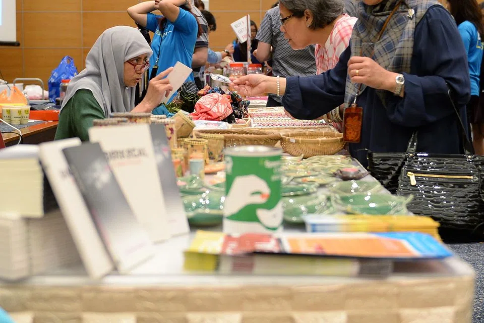 KUMPUL DANA: Dr Radiah (kiri) di gerai Kelab Heal sempena Karnival Amal SPH bagi mengumpulkan dana. Gerai tersebut menjual kraf tangan daripada pesakitnya.