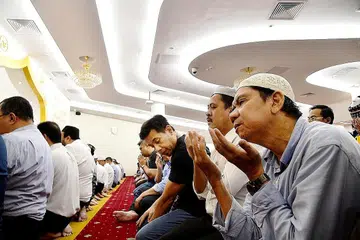 SATU CONTOH KESATUAN DALAM KEPELBAGAIAN: Jemaah bersolat (gambar atas dan bawah) di Masjid Moulana Mohamed Ali di UOB Plaza, Raffles Place. Masjid itu dipengerusikan Muslim Syiah, peguam Mirza Mohamed Namazie, sementara anggota lain lembaga masjid itu merupakan Muslim Sunni. - Foto-foto M.O. SALLEH
