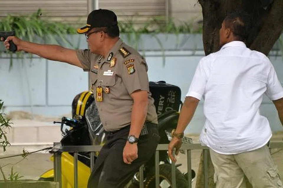 Seorang pegawai polis Indonesia menembak ke arah suspek di luar sebuah kafe di Jakarta pada Khamis, 14 Januari. Gambar AFP 