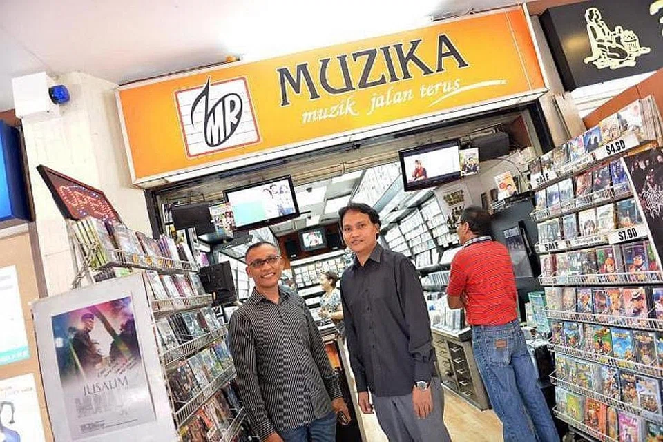 JADI KENANGAN: Encik Salleh (kiri) bersama adiknya, Encik Rosman Abdul Samad, di kedai muzik Muzika Rekod di Joo Chiat Complex tidak lama dulu. - Foto ihsan SALLEH ABDUL SAMAD
