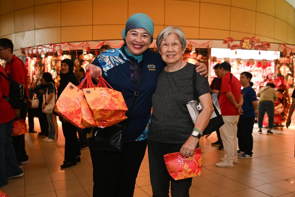 Pengerusi Majlis Jawatankuasa Eksekutif Kegiatan Melayu Persatuan Rakyat (PA Mesra) Cik A.J Suhani Sujari (kiri) bersama Cik Doris Chen, seorang penduduk Toa Payoh yang menerima limau daripada relawan PA Mesra pada 26 Januari di HDB Hub di Toa Payoh pada 26 Januari.