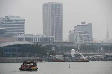 TERUS BERJEREBU: Beginilah keadaan Marina Bay (atas) dan Taman di Persisiran sekitar 2 hingga 3 petang semalam. - Foto BH oleh JASON QUAH, AFP