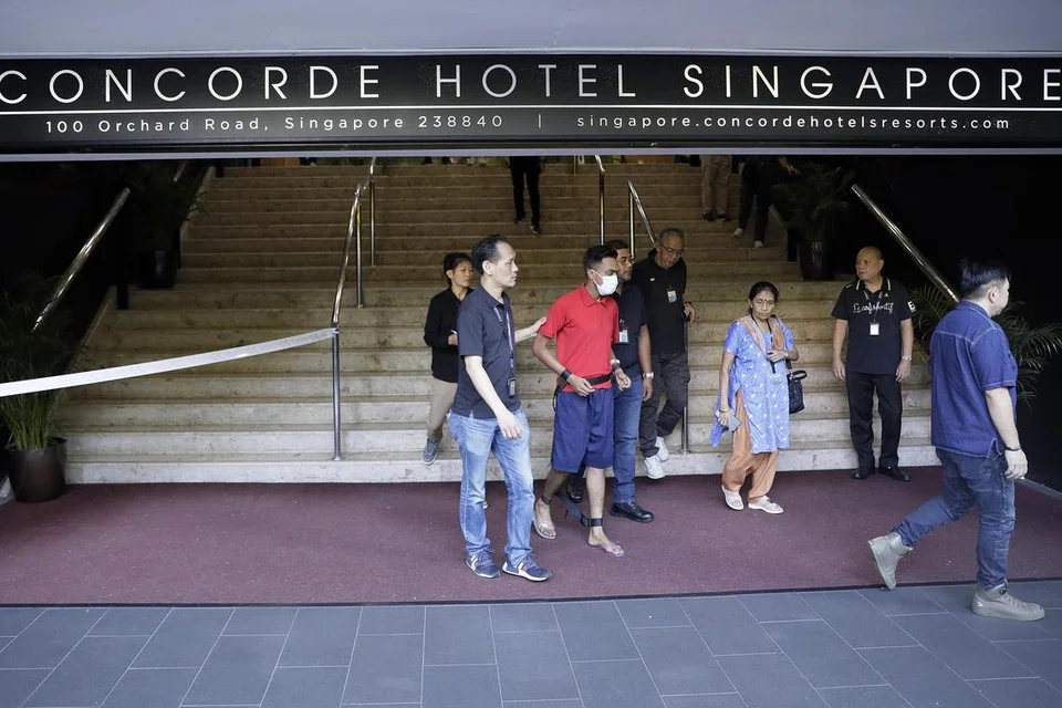 KES PERGADUHAN DI ORCHARD: Asvain Pachan Pillai Sukumaran (berbaju merah), yang didakwa membunuh seorang lelaki, dibawa semula ke tempat kejadian di Orchard Road pada Ahad pagi.