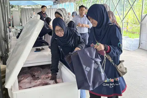 Sukarelawan dilihat membungkus daging korban dari Australia bagi tujuan pengagihan pada 18 Jun, anjuran SalamSG.