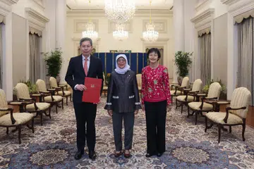 DILANTIK DUTA: Encik Lui Tuck Yew (kiri) dilantik sebagai Duta Singapura seterusnya ke Amerika Syarikat. Presiden Halimah Yacob (tengah) serah Watikah Tauliah kepadanya dalam satu upacara di Istana pada 30 Mei.