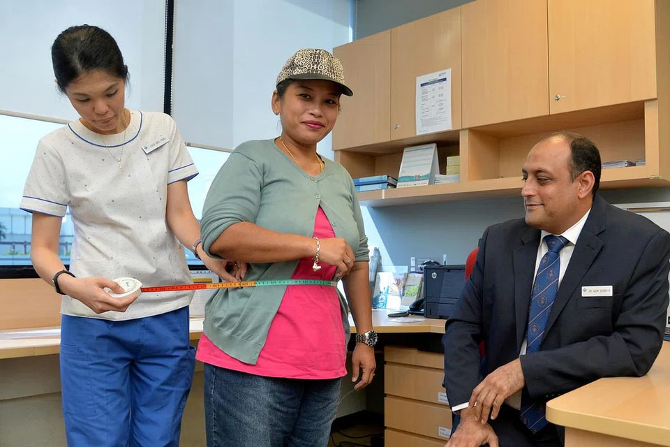 LEBIH KURUS, LEBIH SIHAT: Cik Zubaidah Hassan Basri (tengah) dapat mengurangkan berat badannya selepas menjalani pembedahan 'Laparoscopic sleeve gastrectomy' (LSG). Duduk di kanan ialah Dr Asim Shabbir - Pengarah, Perkhidmatan Klinikal di Jabatan Pembedahan NUH. - Foto M.O. SALLEH