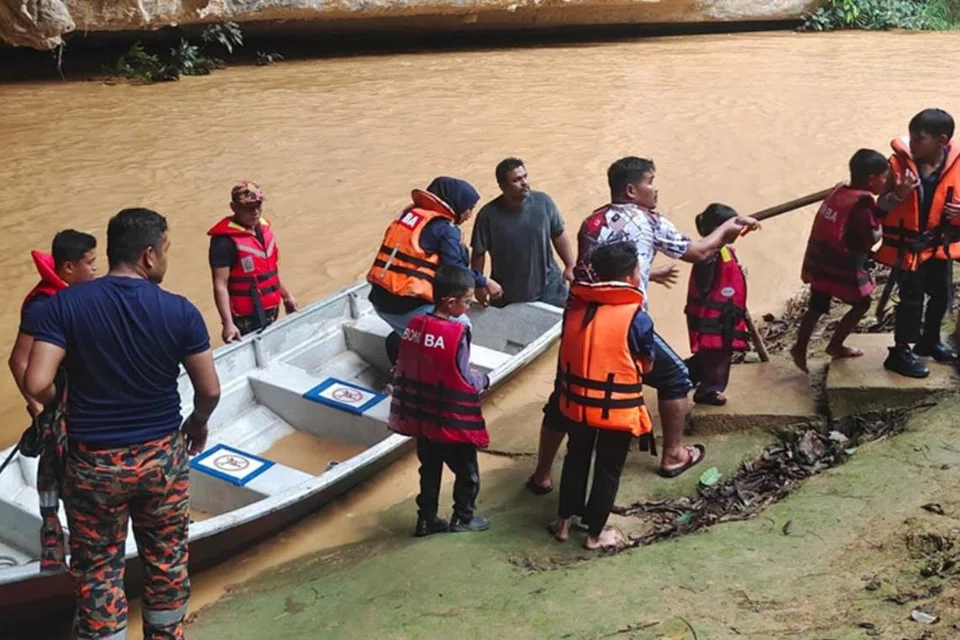 Anggota penyelamat dari Balai Bomba dan Penyelamat (BBP) Dabong, Kuala Krai, Kelantan, memindahkan 40 mangsa rombongan sekolah yang terperangkap dalam kejadian kepala air di Gua Ikan, Dabong, Kuala Krai, Kelantan, pada 21 November.