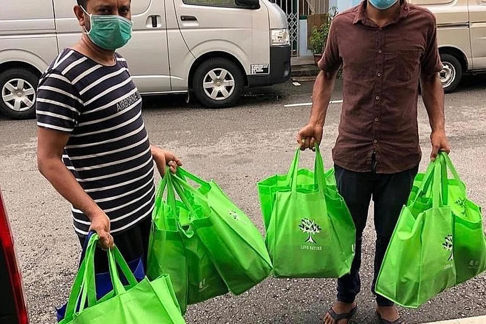 AGIH SINAR PERAYAAN: Pek jagaan diagihkan kepada pekerja asing di asrama-asrama serata Singapura termasuk kilang yang ditukar menjadi asrama. - Foto ihsan DR HUMAIRAH ZAINAL