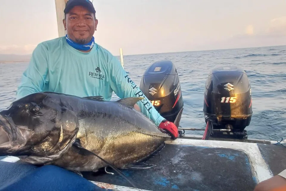 Encik Nazri Mahat bergambar dengan ikan ‘trevally’ gergasi atau ‘giant trevally’ di Sumbawa, Indonesia.
