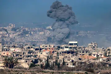 Kepulan asap kelihatan di Jaluran Gaza di tengah-tengah bangunan yang musnah pada 13 Januari ekoran pertempuran berterusan antara Israel dengan Hamas.