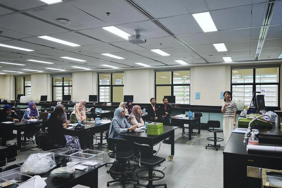 Guru-guru mata pelajaran Sains dari Johor mendengar penerangan tentang pengajaran makmal di Institut Pendidikan Nasional Singapura pada 9 April.