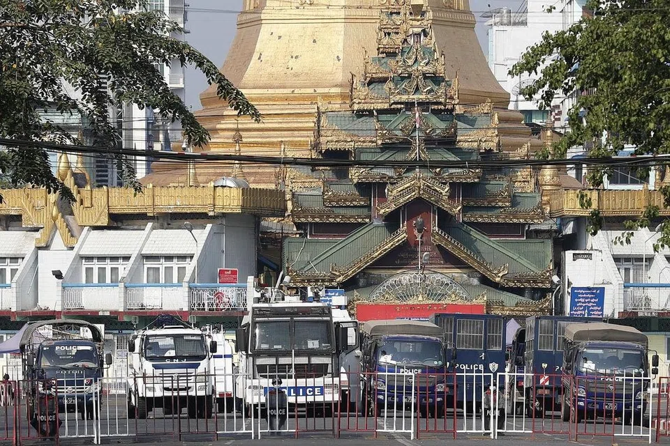 SEKATAN: Pihak tentera meletakkan sekatan di jalan raya menuju ke pintu masuk Kuil Sule di Yangon demi mencegah orang ramai berkumpul di kawasan itu. - Foto EPA-EFE