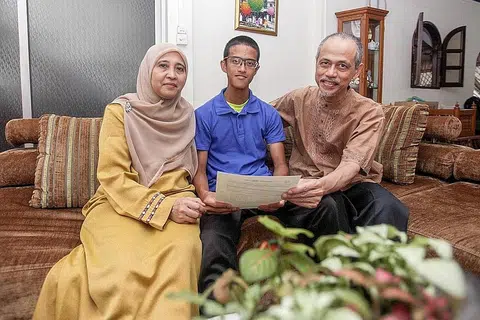MAHU JADI DOKTOR GIGI: Muhammad Nurhaziq Sahul H yang diapit ibu bapanya, Encik Sahul Hameed, 57 tahun, dan Cik Safiah Misrak, 55 tahun, menerima keputusan peperiksaan Sijil Am Pelajaran (GCE) Peringkat 'O' kelmarin di Sekolah Menengah Mayflower. - Foto BM oleh IQBAL FAIZAL