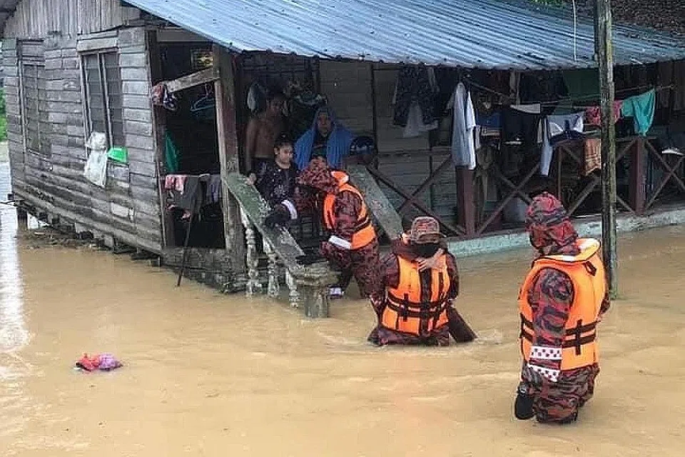 DISELAMATKAN BOMBA: Pasukan keselamatan membantu memindahkan penduduk di kawasan Kota Tinggi dan Mersing yang rumah mereka dinaiki air akibat hujan lebat tidak berhenti sejak malam kelmarin. - Foto The Voice Facebook