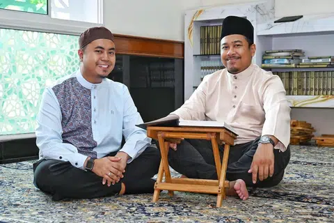 Di bawah kumpulan sayap belia Ayman Al-Iman, Ustaz Khaider Rohani (kanan), yang merupakan Pegawai Pembangunan Belia waktu itu telah mendorong anak muda seperti Encik Muhammad Hafiyyan Abdul Rasid (kiri) untuk tampil menjadi bilal dan imam di masjid.