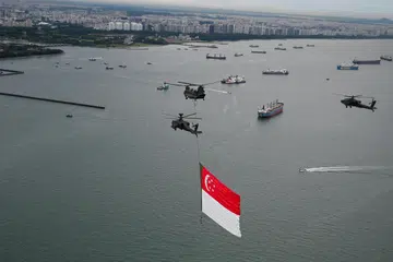 Dua helikopter Pejuang, Apache AH-64D akan mengiringi sebuah Chinook (tengah) ketika segmen ‘Kibarkan Bendera Kita’ di seluruh pulau. 