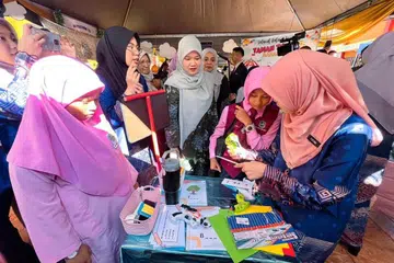 Menteri Pendidikan Malaysia, Cik Fadhlina Sidek (tengah), menyantuni murid Sekolah Kebangsaan Sungai Bakap, Nibong Tebal, Pulau Pinang, selepas merasmikan Program Sekolah Pengajar dan Memartabatkan Bahasa Melayu dan Memperkukuh Bahasa Inggeris (MBMMBI): Sahabat Bahasa Institut Pendidikan Guru Malaysia, pada 20 Jun.