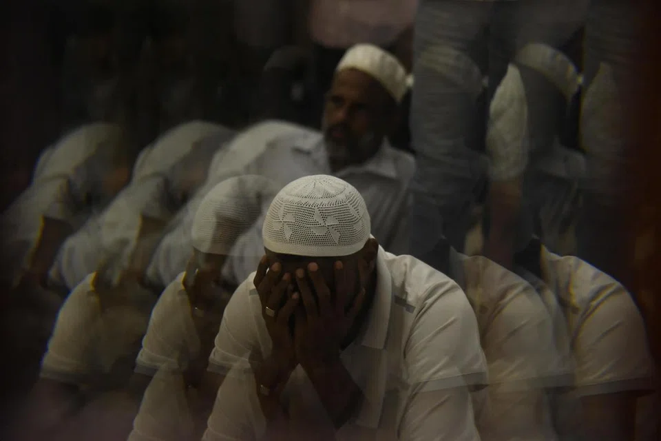 Seorang lelaki sedang khusyuk berdoa dalam Ramadan.