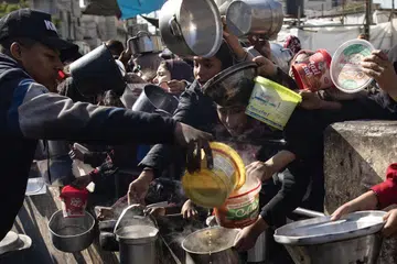UNTUK SESUAP NASI: Rakyat Palestin memegang periuk kosong ketika berbaris untuk mendapatkan bantuan makanan yang disediakan oleh kumpulan pemuda Palestin di kem pelarian Rafah, sedang terdapat laporan sebilangan penduduk mengisar makanan haiwan ternakan sebagai bahan menghasilkan roti kerana kekurangan tepung gandum.