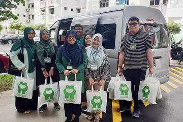 AGIH BANTUAN: Relawan Club Heal mengagihkan bantuan berupa baucar dan hamper kepada 60 warga kurang bernasib baik di kawasan Marsiling, Woodlands, dan Sembawang kelmarin dan semalam. - Foto CLUB HEAL