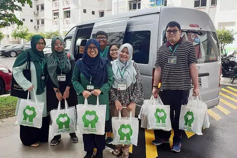 AGIH BANTUAN: Relawan Club Heal mengagihkan bantuan berupa baucar dan hamper kepada 60 warga kurang bernasib baik di kawasan Marsiling, Woodlands, dan Sembawang kelmarin dan semalam. - Foto CLUB HEAL
